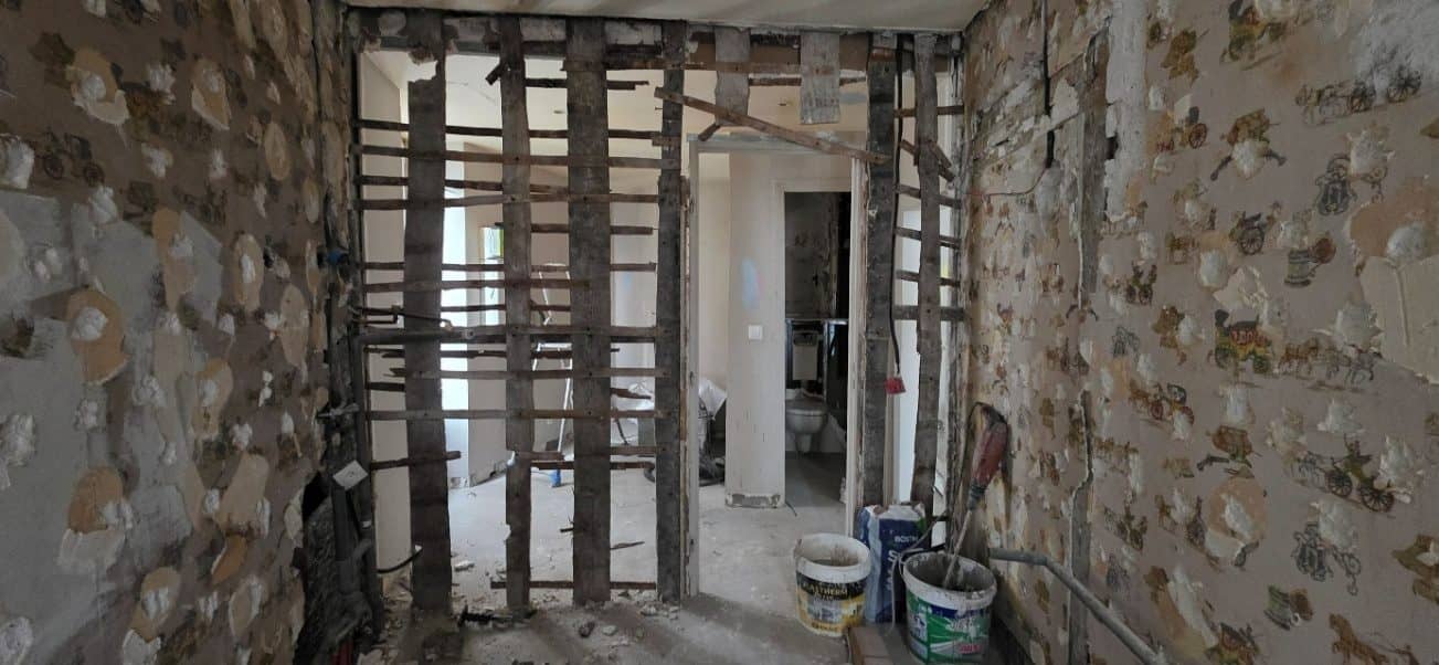 Mur intérieur mis à nu : montants et traverses en bois d’un immeuble ancien, avant ouverture