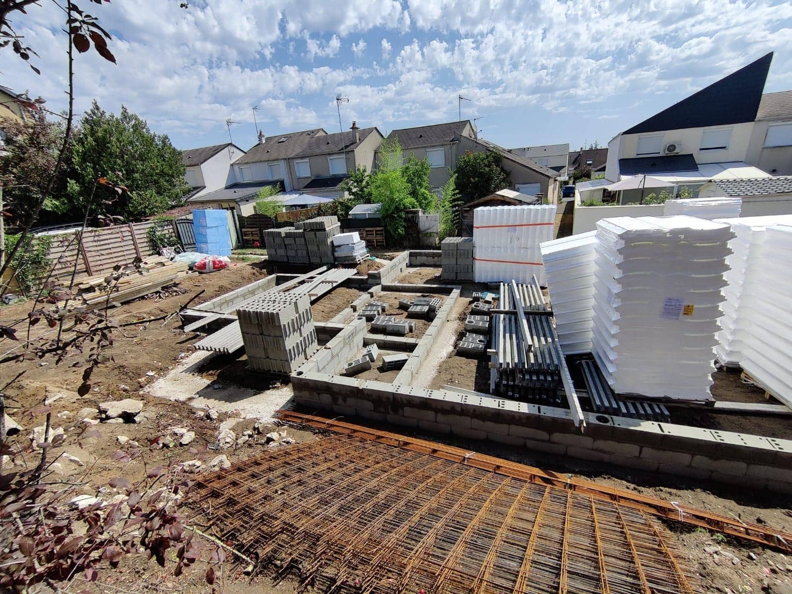 Gros œuvre d'une maison en construction avec murs de fondation en parpaings, hourdis et treillis soudé