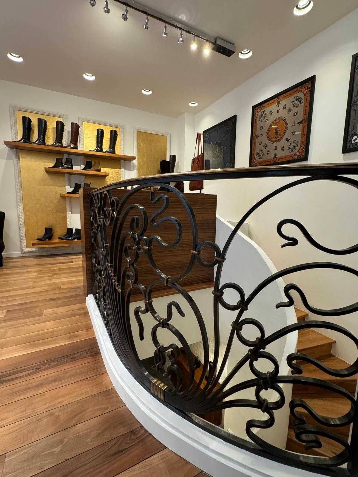 Boutique de chaussures avec garde-corps en fer forgé, escalier hélicoïdal et parquet en bois