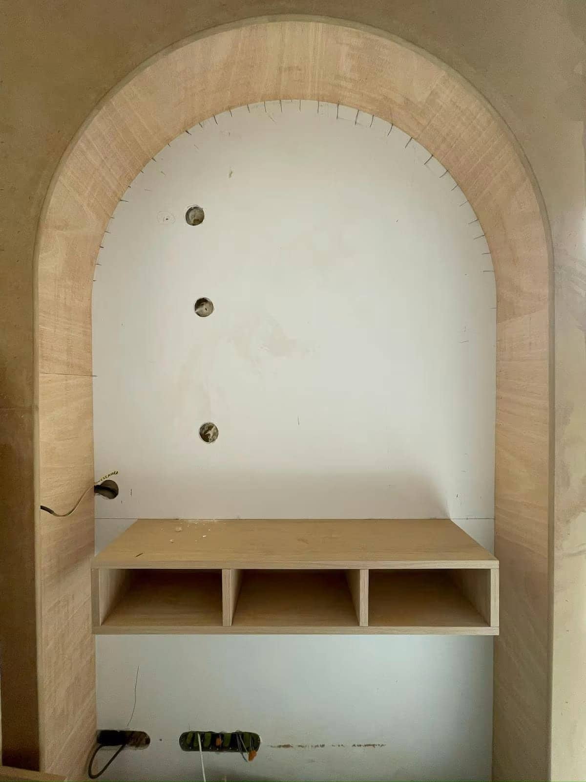 Niche en arche en chêne avec meuble suspendu à trois casiers, en cours de pose