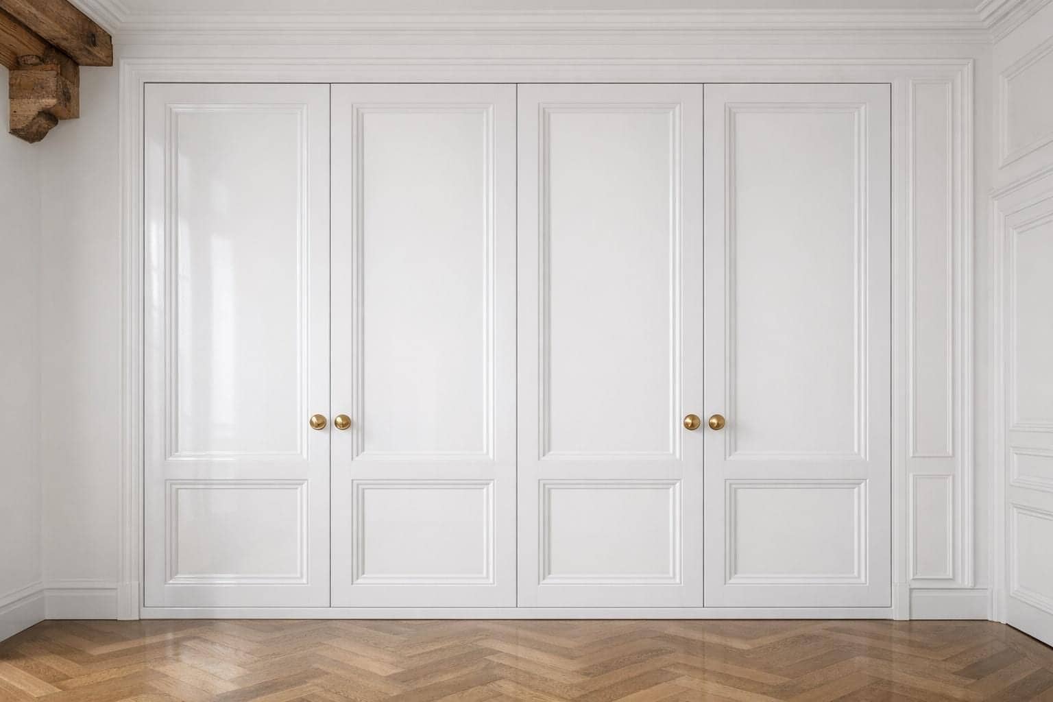 Placard sur mesure blanc à portes moulurées et poignées dorées, parquet en point de Hongrie à Paris